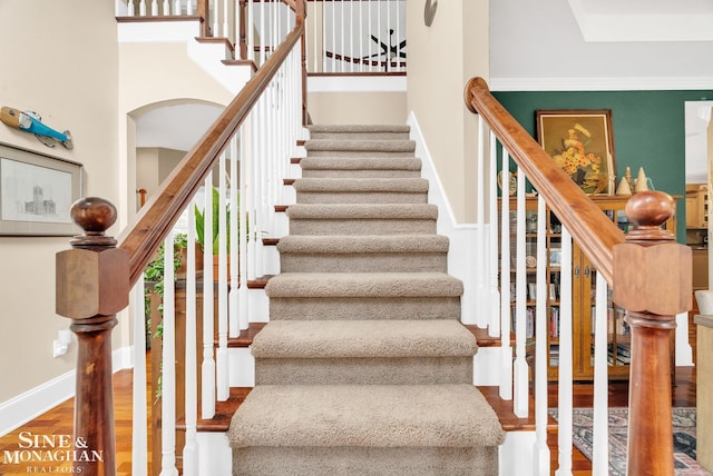 3325 Saint Andrews Dr, Port Huron, MI 48060 - stairs featuring wood finished floors, arched walkways, and a towering ceiling