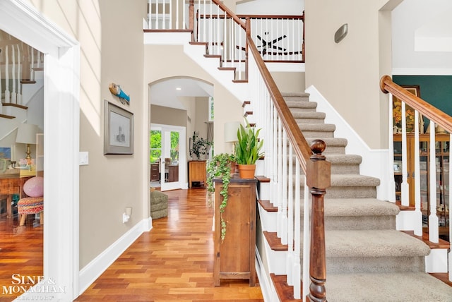 3325 Saint Andrews Dr, Port Huron, MI 48060 - staircase featuring arched walkways, wood finished floors, and a towering ceiling
