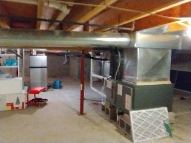 11374 S Shore Dr, Lake, MI 48632 - unfinished basement featuring freestanding refrigerator and heating unit