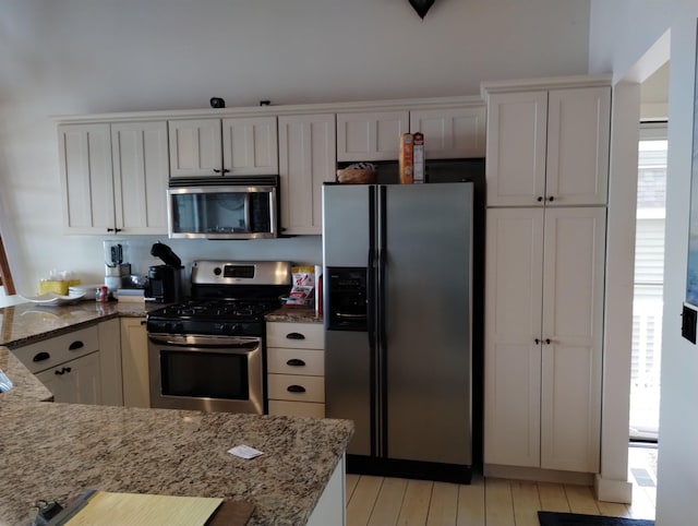 11374 S Shore Dr, Lake, MI 48632 - kitchen featuring appliances with stainless steel finishes, light stone counters, and white cabinets