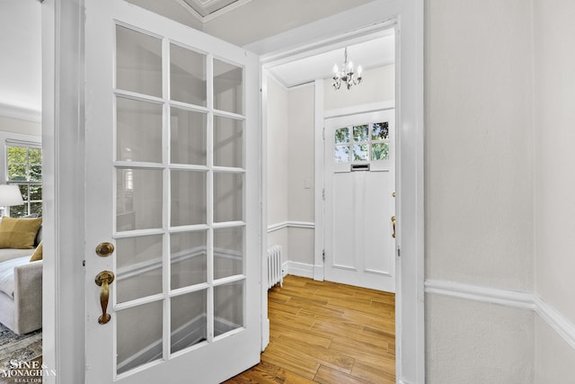 488 University Pl, Grosse Pointe, MI 48230 - entryway featuring radiator, wood finished floors, plenty of natural light, and a chandelier