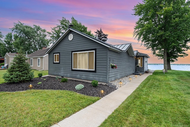 319 Old Trail Dr, Houghton Lake, MI 48629 - ranch-style home with a front yard, a water view, a metal roof, and a standing seam roof
