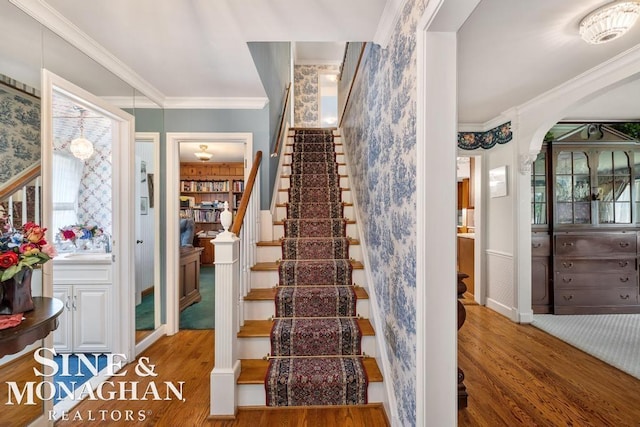 28 Hampton Rd, Grosse Pointe Shores, MI 48236 - stairs featuring wood finished floors, arched walkways, crown molding, healthy amount of natural light, and wallpapered walls