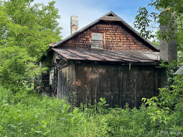 798 S Cedar St, Ewen, MI 49925 - view of side of home featuring a chimney, an outdoor structure, and a shingled roof
