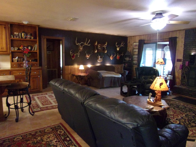 living room featuring ceiling fan and wood walls