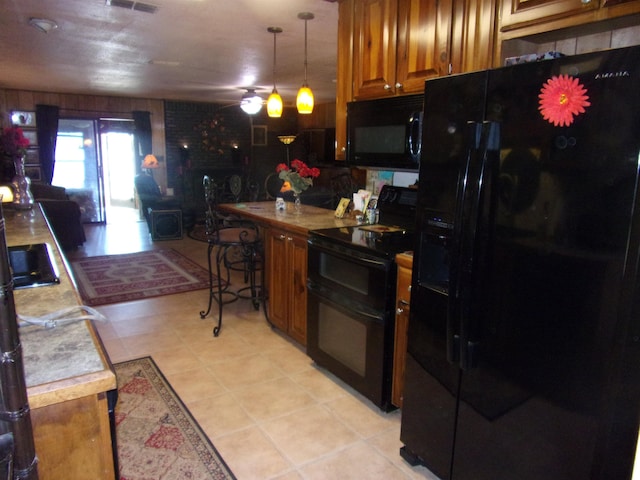 kitchen featuring black appliances, pendant lighting, and light tile patterned flooring