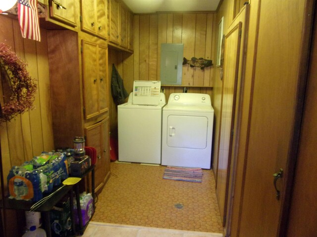 laundry area with wood walls, cabinets, independent washer and dryer, and electric panel