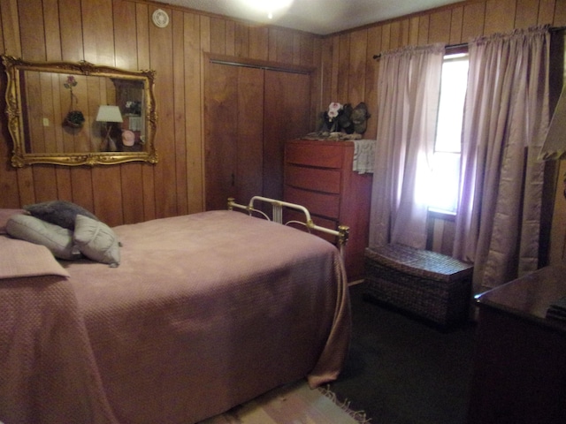 bedroom featuring multiple windows, wooden walls, and a closet