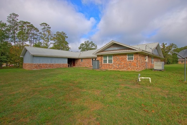 view of front of home with central AC and a front lawn