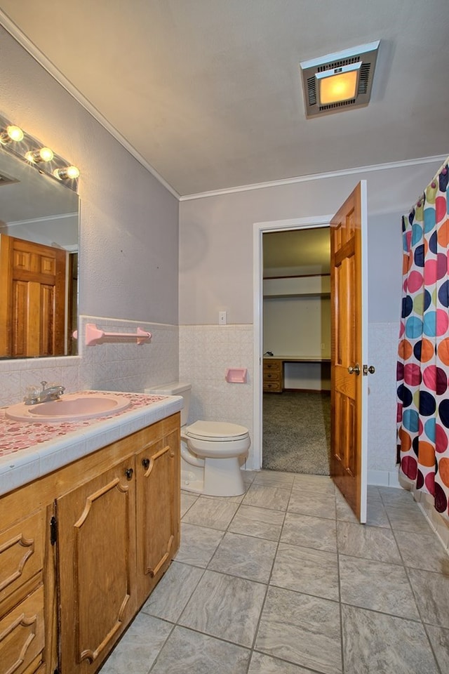 bathroom featuring curtained shower, toilet, vanity, tile walls, and ornamental molding