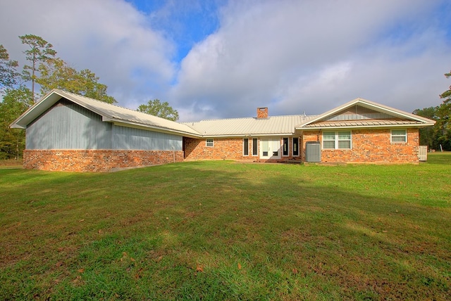 rear view of house with a yard and central AC