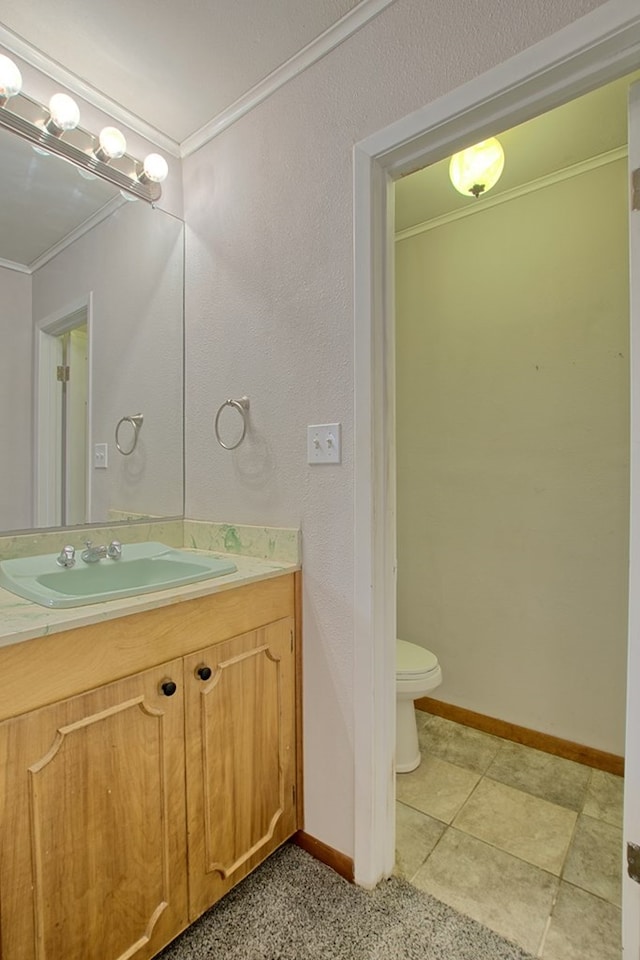 bathroom with vanity, toilet, and crown molding