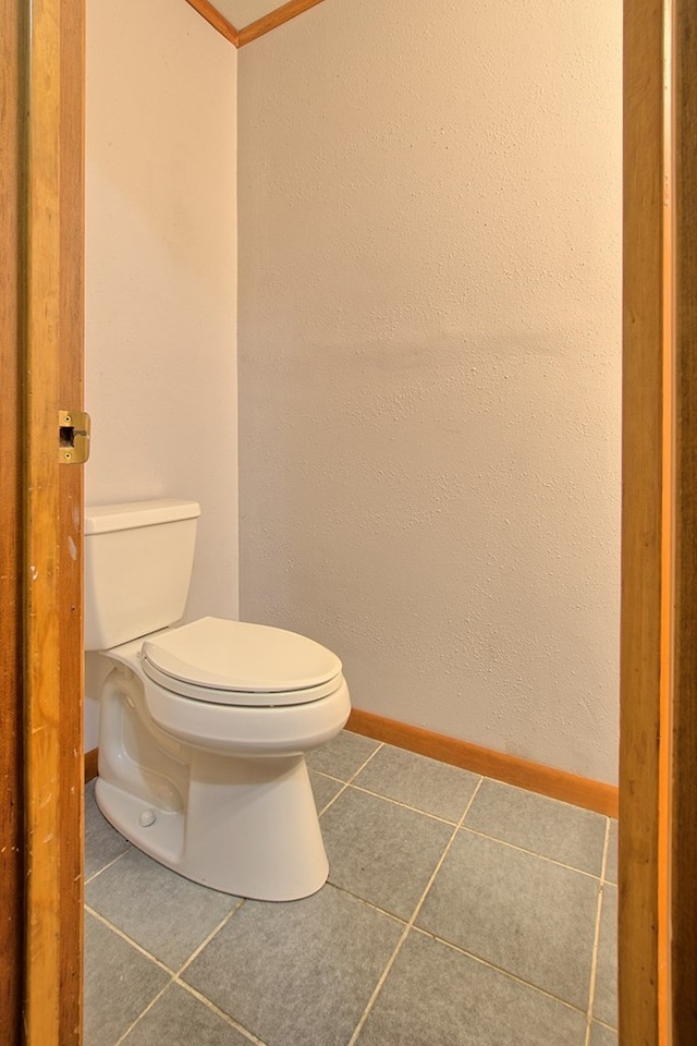 bathroom with toilet, tile patterned floors, and crown molding