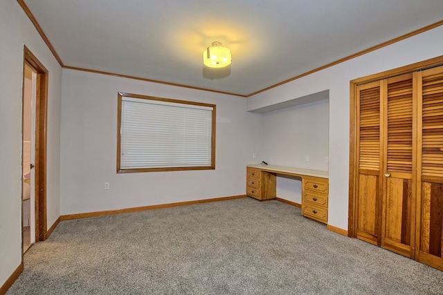 unfurnished bedroom with light carpet, built in desk, a closet, and crown molding