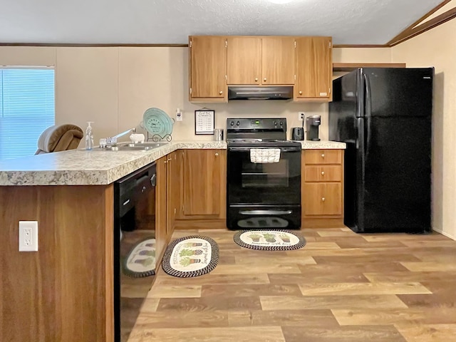 228 Blue Jay Dr, Brookeland, TX 75931 - kitchen featuring light countertops, a peninsula, under cabinet range hood, a sink, and black appliances