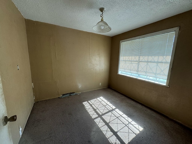 carpeted empty room with a textured ceiling