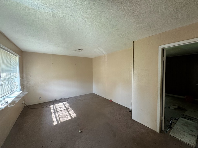 carpeted spare room featuring a textured ceiling