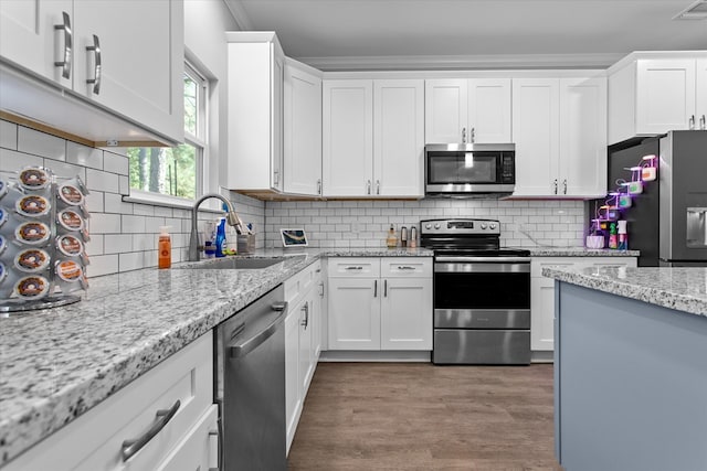 kitchen with backsplash, white cabinetry, sink, and appliances with stainless steel finishes