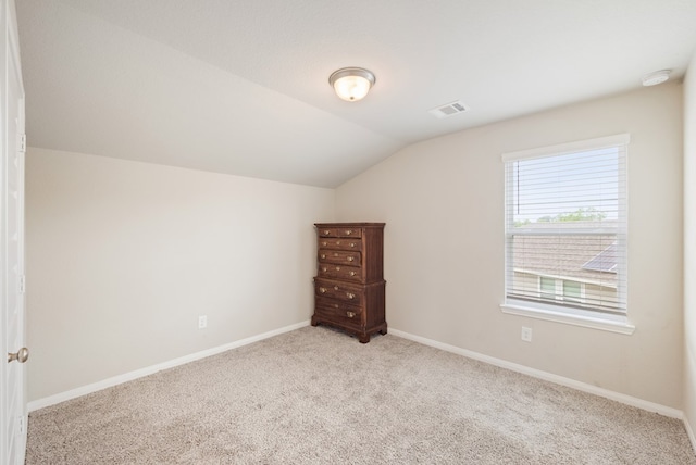 additional living space featuring visible vents, baseboards, lofted ceiling, and carpet