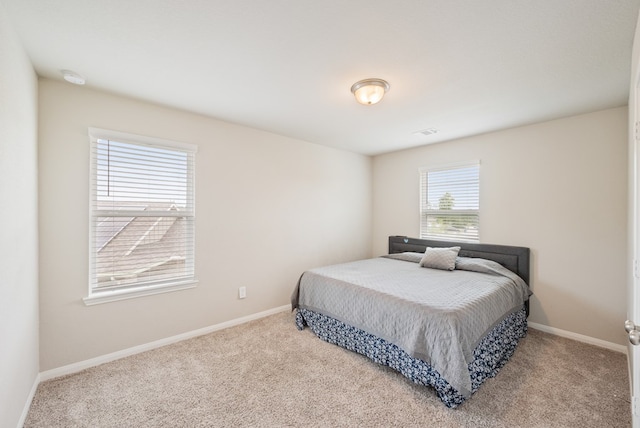 carpeted bedroom featuring baseboards and visible vents