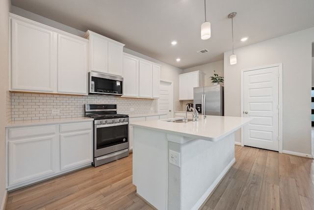kitchen featuring a sink, appliances with stainless steel finishes, light wood-style floors, and visible vents