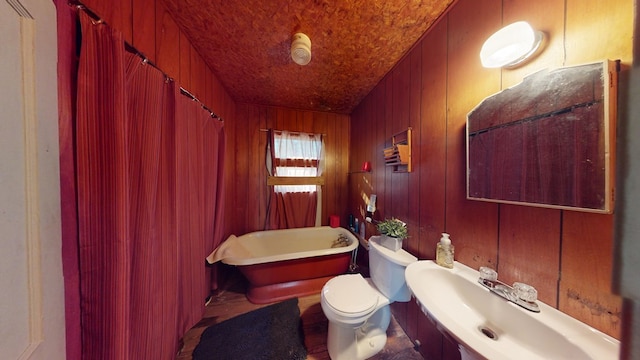 bathroom with toilet, wood walls, and a bath