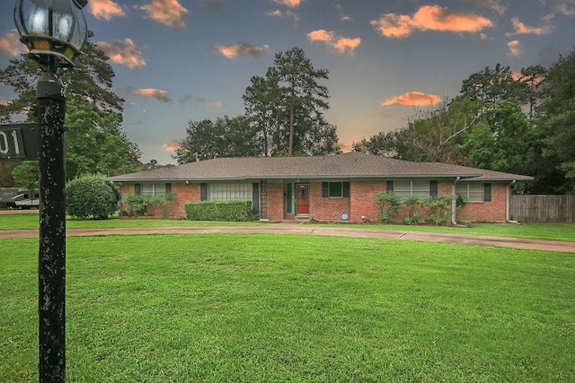 ranch-style home with a yard