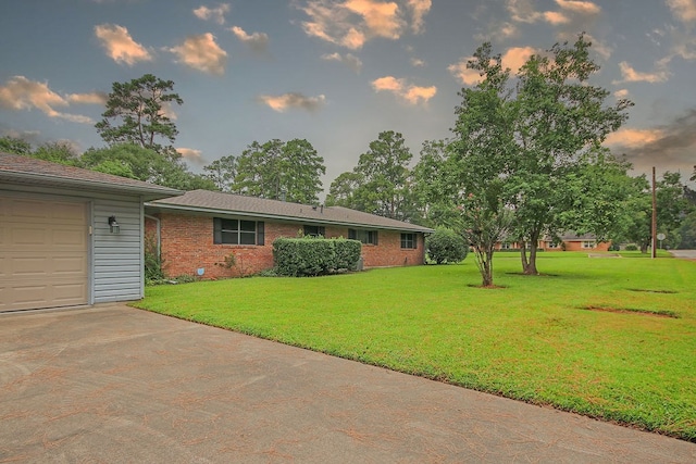 yard at dusk featuring a garage