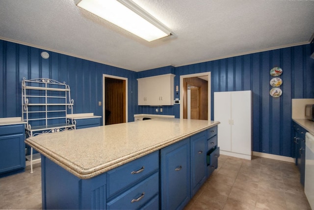 kitchen with blue cabinetry, a textured ceiling, a kitchen island, and crown molding