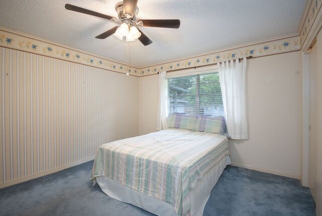 carpeted bedroom with ceiling fan and a textured ceiling