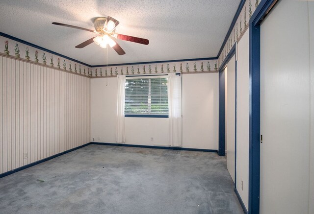 carpeted spare room with a textured ceiling and ceiling fan