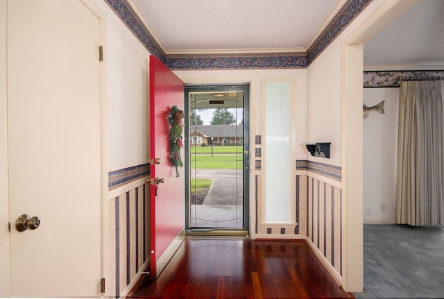 foyer featuring crown molding, dark hardwood / wood-style flooring, and a textured ceiling