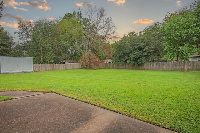 yard at dusk featuring a patio area