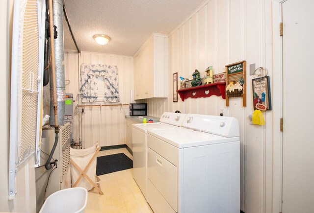 washroom with separate washer and dryer, a textured ceiling, and ornamental molding