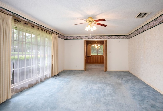 carpeted empty room with ceiling fan with notable chandelier and a textured ceiling