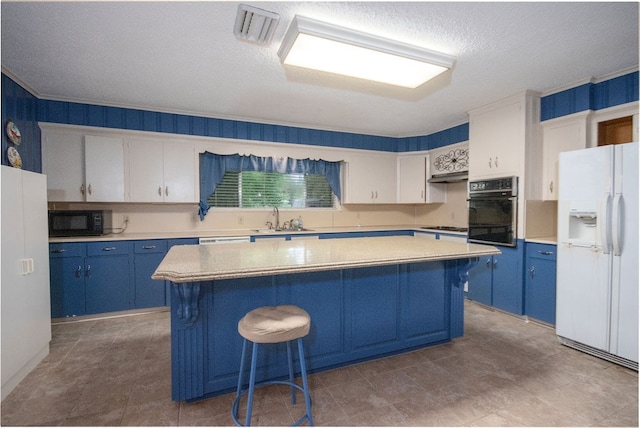 kitchen featuring white refrigerator with ice dispenser, a center island, white cabinets, and sink