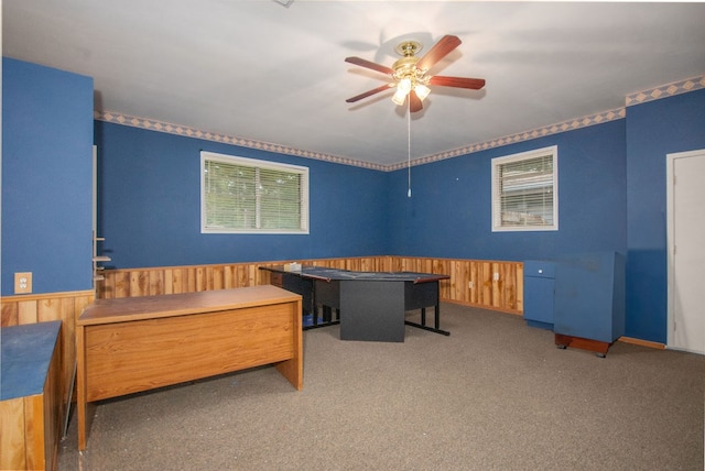 carpeted bedroom with wooden walls and ceiling fan