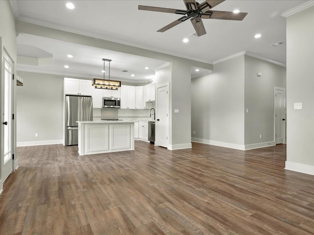 unfurnished living room featuring ceiling fan with notable chandelier, dark wood-style flooring, baseboards, and crown molding