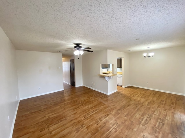 unfurnished living room featuring hardwood / wood-style floors, ceiling fan with notable chandelier, and a textured ceiling