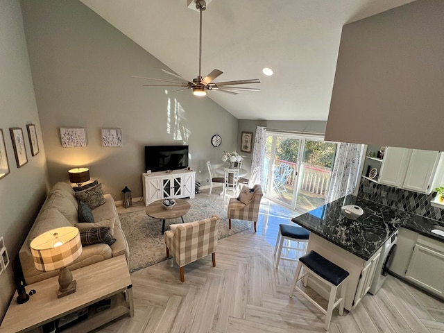 living room with ceiling fan, light parquet floors, and vaulted ceiling