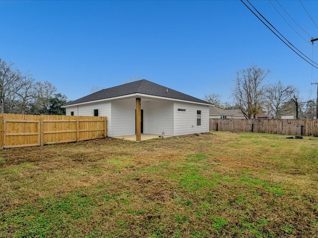 back of house featuring a patio area and a lawn