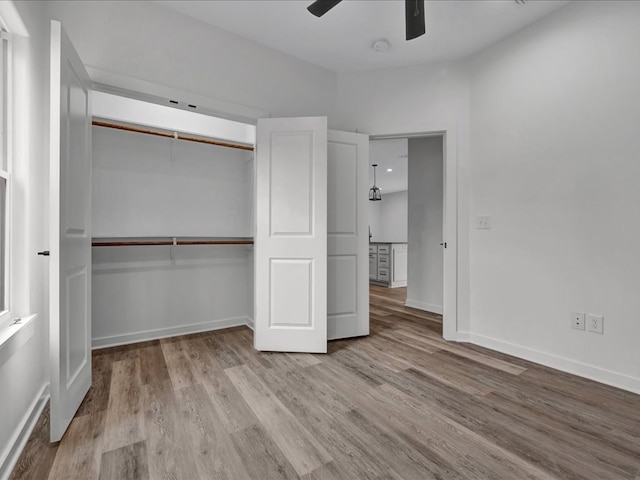 unfurnished bedroom featuring ceiling fan, light hardwood / wood-style floors, and a closet