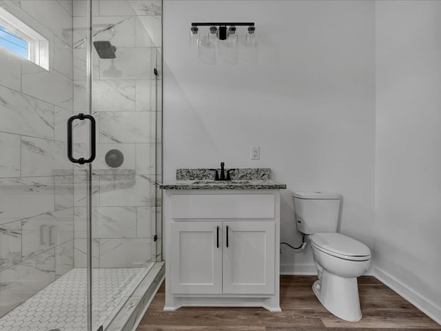 bathroom with vanity, hardwood / wood-style floors, a shower with shower door, and toilet