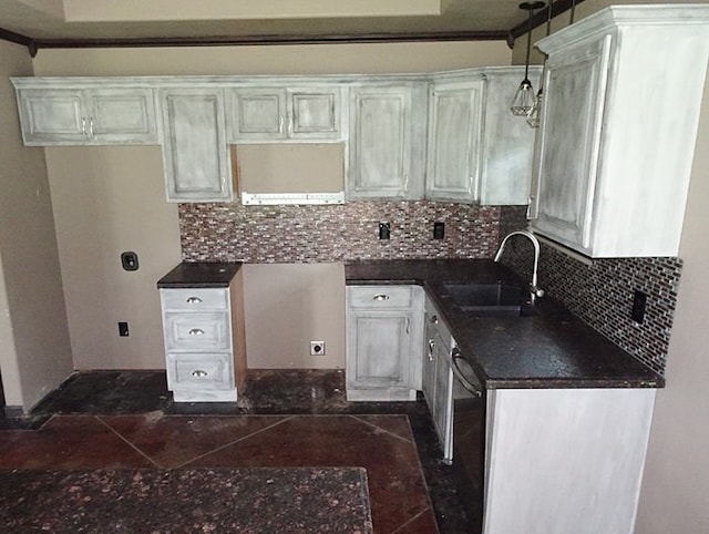 kitchen with white cabinets, backsplash, sink, and hanging light fixtures