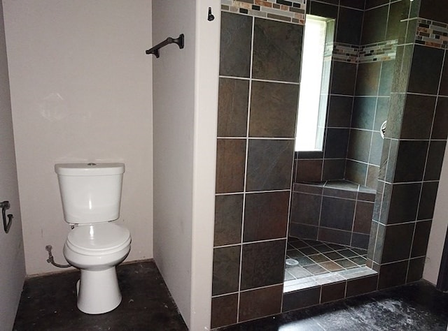 bathroom featuring toilet and tiled shower