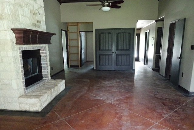 interior space featuring ceiling fan, dark tile patterned floors, and a towering ceiling