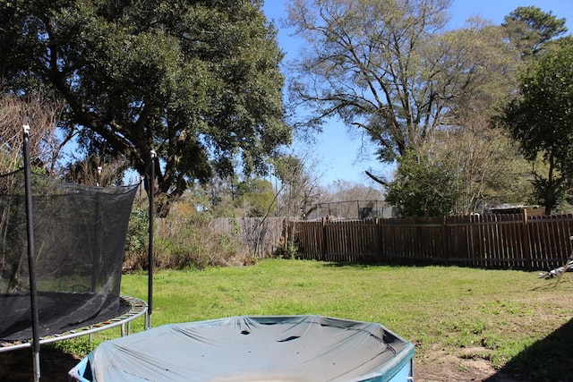 view of yard with a fenced backyard and a trampoline