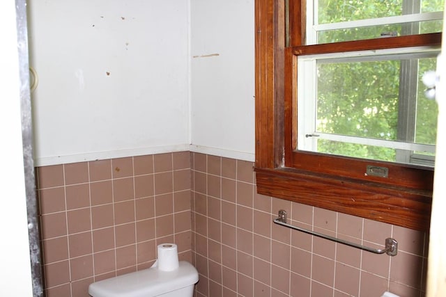 half bathroom with tile walls and toilet