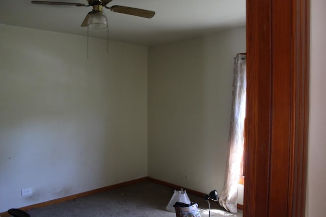 carpeted empty room featuring baseboards and a ceiling fan