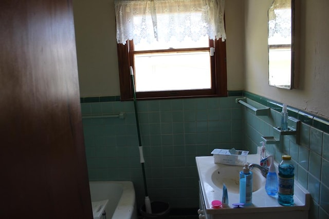 full bathroom featuring a bath, wainscoting, vanity, and tile walls